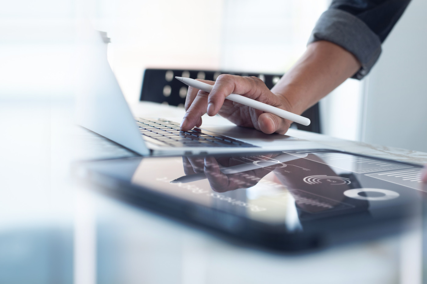 Geschäftsfmann arbeiten mit Stift in der Hand am Laptop.