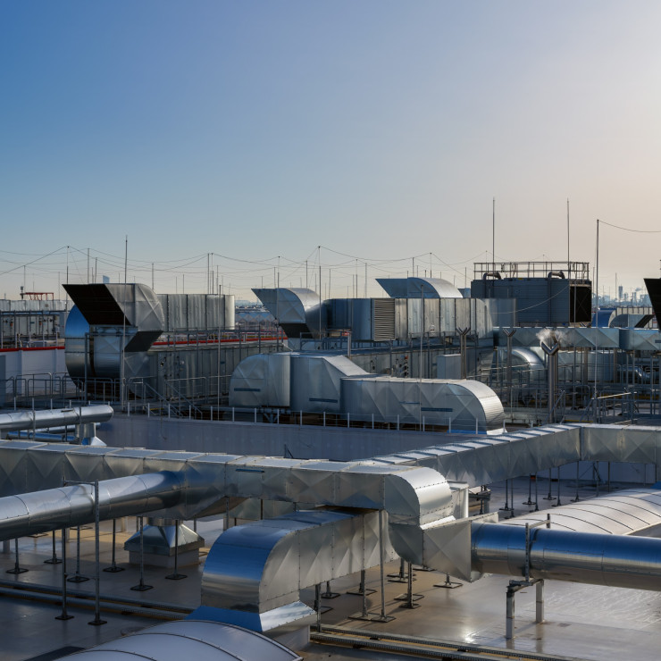 Verschiedene industrielle, mechanische und elektrische Installationen auf dem Dach eines Gebäudes.